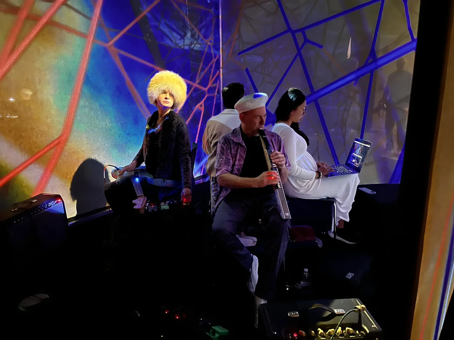 Christine Southworth and fellow musicians performing Arachnodrone amid colorful spider-web projections at MIT Museum